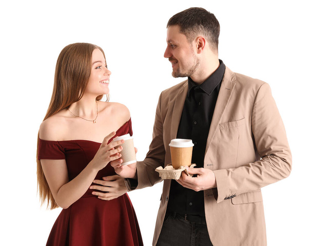 Young man giving cup of coffee to his wife on white background - Photo, Image