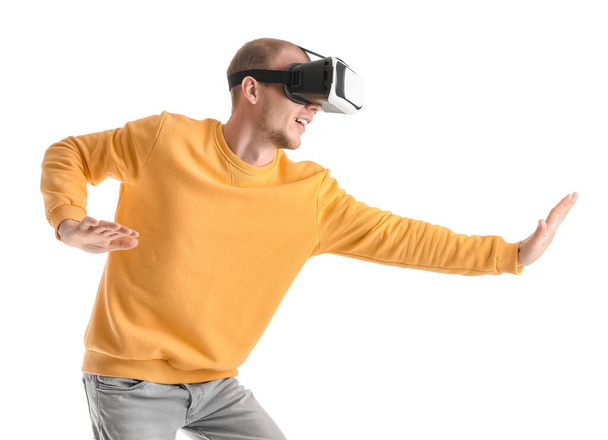Young man using VR glasses on white background - Fotó, kép