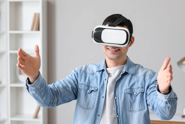 Νεαρός που χρησιμοποιεί γυαλιά εικονικής πραγματικότητας στο σπίτι - Φωτογραφία, εικόνα