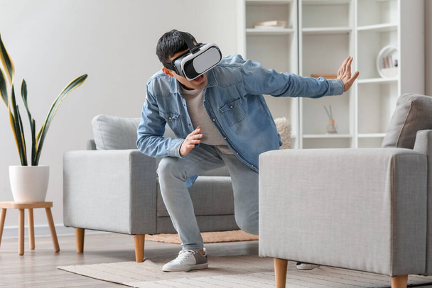 Молодий чоловік використовує VR окуляри вдома
 - Фото, зображення