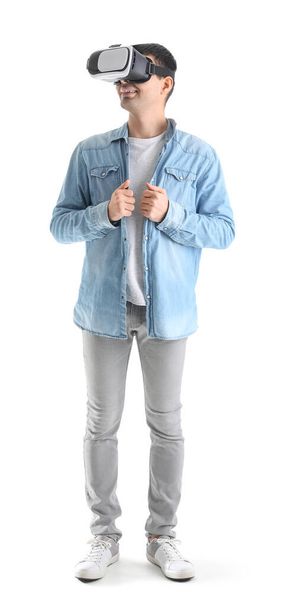 Young man using VR glasses on white background - Photo, Image
