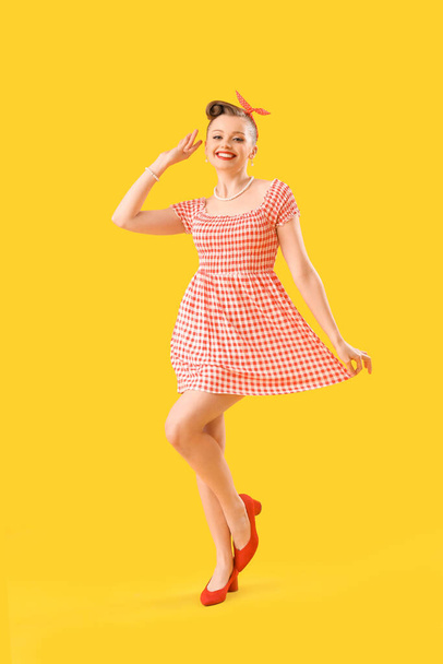 Young pin-up woman in dress on yellow background - Foto, Imagem
