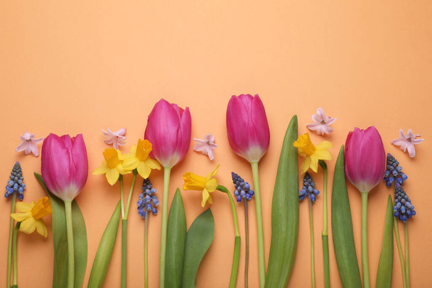 Beautiful different flowers on orange background, flat lay. Space for text - 写真・画像