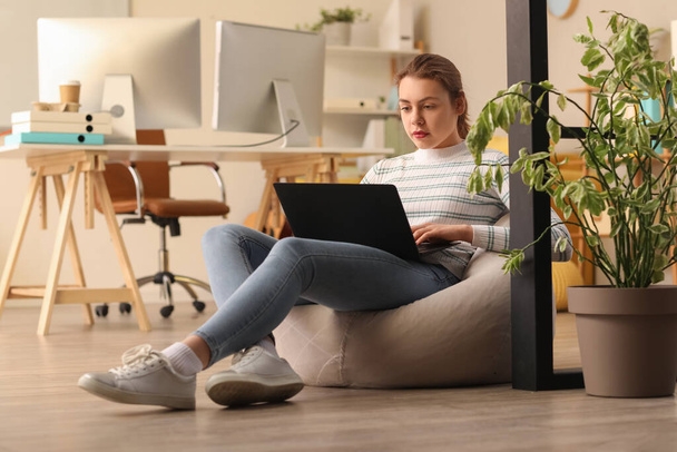 Programadora femenina trabajando con laptop en oficina - Foto, Imagen
