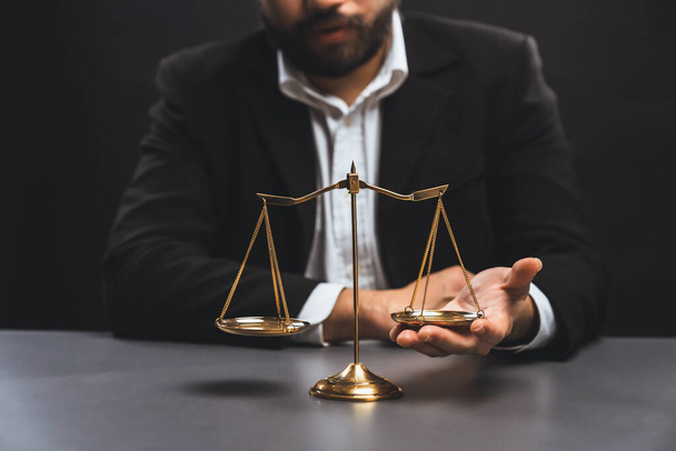 Фокус золотого масштабу балансу з підпаленим тлом адвоката в чорному костюмі сидить на його офісному столі, символ правосуддя і цілісності, збалансоване і етичне рішення в суді правової рівності
 - Фото, зображення