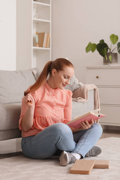 Young woman reading book at home - Fotó, kép