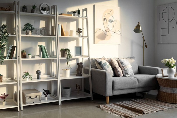 Interior da sala de estar leve com sofá, unidades de estantes e plantas artificiais - Foto, Imagem