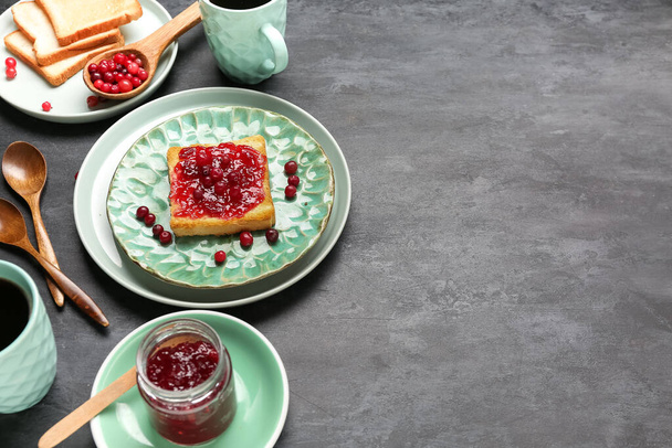 Plates of tasty toast with cranberry jam on dark background - Foto, Imagen