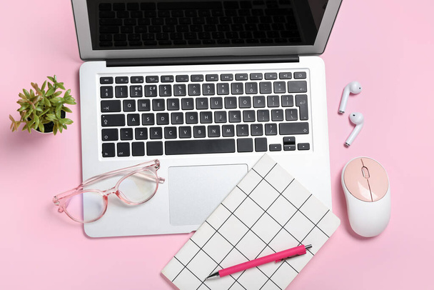 Composición con portátil, anteojos y bloc de notas sobre fondo rosa - Foto, Imagen