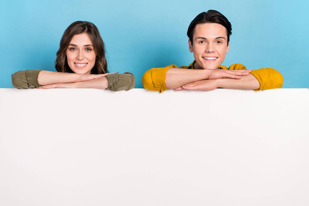 Closeup photo of two smiling people folded arms on big whiteboard empty space new website advert promo code offer isolated on blue color background. - Photo, Image