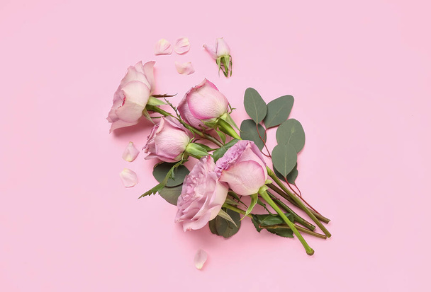 Beautiful roses with eucalyptus branches on pink background - Foto, Imagem