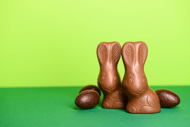 Chocolate bunnies and Easter eggs on green background - Zdjęcie, obraz