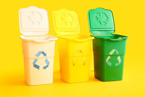 Containers for garbage on yellow background. Recycling concept - Fotó, kép