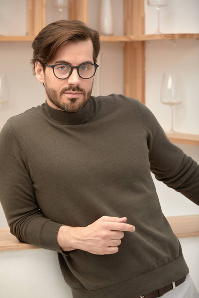 Young handsome man with beard wearing casual sweater and glasses happy face smiling with crossed arms looking at camera. A positive person - Fotografie, Obrázek
