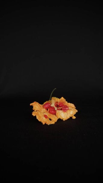 Portrait Of Selective Focus From Front View And Half Cut Yellow Bitter Gourd Over Ripe And Burst Out With Red Seeds Isolated On Black Cloth Background - Foto, Imagen