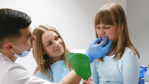 Una madre con la sua figlioletta ad un consulto con un dentista. Trattamento dentale nei bambini. Video 4k di alta qualità - Filmati, video