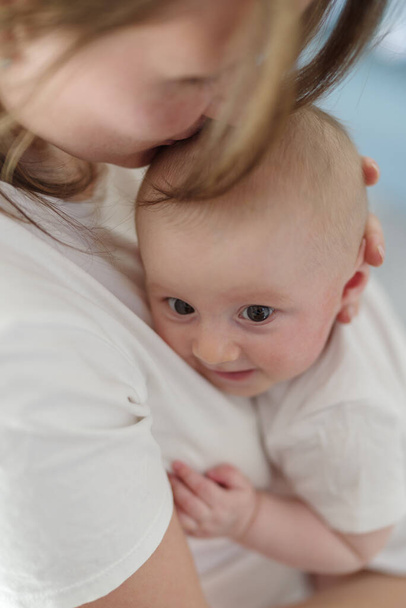 Любляча і ласкава мати тримає новонароджену дитину
 - Фото, зображення