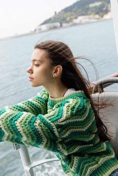 Seitenansicht einer jungen Frau im Strickpullover auf einer Jacht in der Türkei  - Foto, Bild