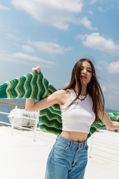 Portrait of brunette woman holding sweater during cruise on ferry boat in Turkey  - Photo, Image
