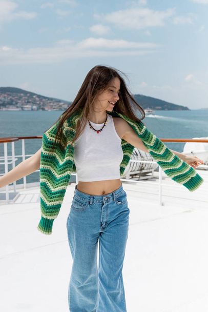Overjoyed woman with sweater standing on yacht during cruise in Turkey  - Φωτογραφία, εικόνα