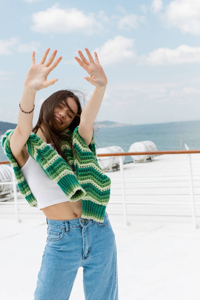 Carefree traveler with sweater outstretching hands during cruise in Turkey  - Photo, Image
