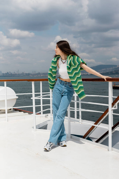 Side view of brunette woman looking away while standing on ferry boat in Turkey  - Fotó, kép