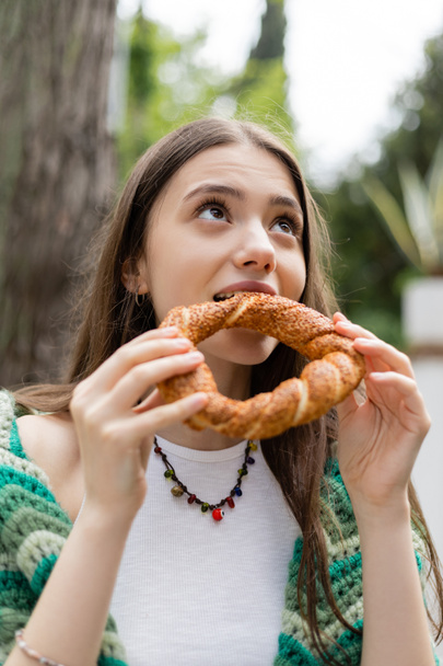 Brunette woman eating traditional turkish simit bread in Istanbul - Foto, afbeelding