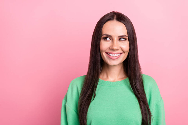 Photo of satisfied cute woman with straight hairdo dressed green sweatshirt look empty space at sale isolated on pink color background. - Fotografie, Obrázek