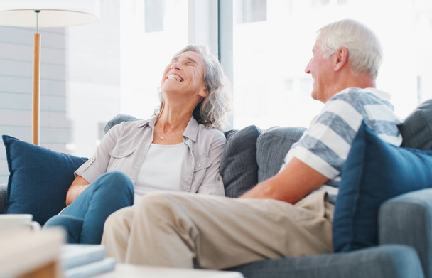 Make time to make each other laugh. a senior couple relaxing on the sofa at home - Foto, imagen
