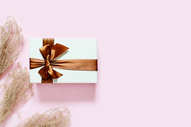 Blank greeting card, invitation and envelope mockup. Minimal floral frame made of dry flowers and branches and a gift. Flat lay, top view. Happy mother's day, birthday, wedding composition. - Foto, imagen