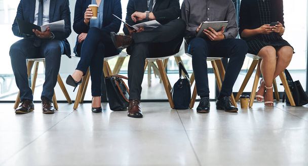 Tik-tak... ketyeg az idő. egy csapat felismerhetetlen üzletember, akik sorban állnak egy interjúért egy modern irodában. - Fotó, kép