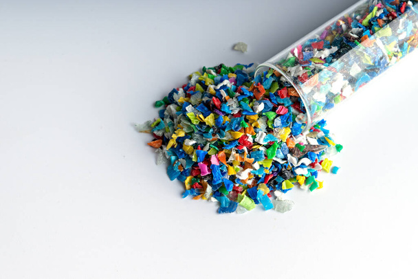 Small pieces of crushed plastic. Crushed bottle caps for recycling. Plastic waste that will be mixed with plastic vergin. Concept reducing plastic. - Photo, Image