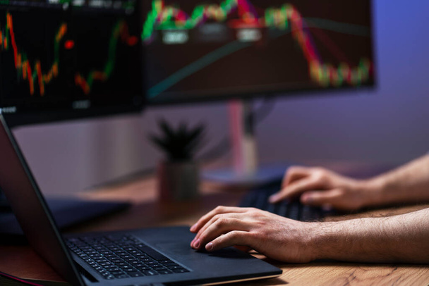 Closeup of crypto trader hands using laptop, typing on keyboard, working online with crypto chart sitting in modern office, researching and analyzing market. Successful business, online trading - Foto, afbeelding