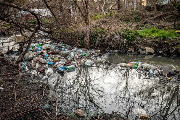 Différentes ordures plastiques dans la rivière, concept de pollution et d'environnement. - Photo, image