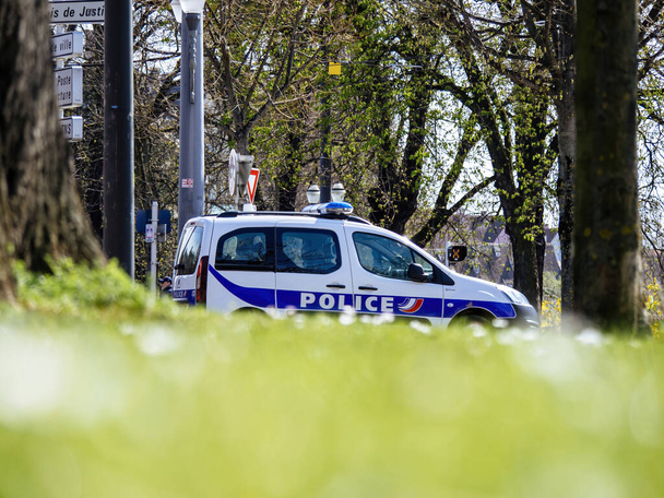 Strasborg, France - Mar 29, 2023: A police car is parked amidst trees and plants in a park, with selective focus emphasizing its rallying force as a mode of transportation. - Foto, immagini