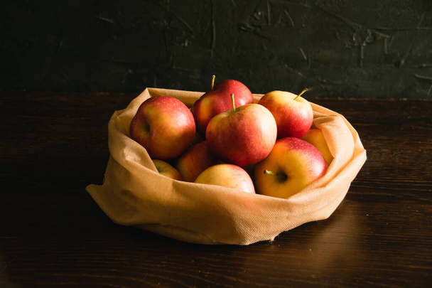 Pyszne jabłka w torebce wielokrotnego użytku na owoce i warzywa. Koncepcja dnia Ziemi i recyklingu odpadów - Zdjęcie, obraz