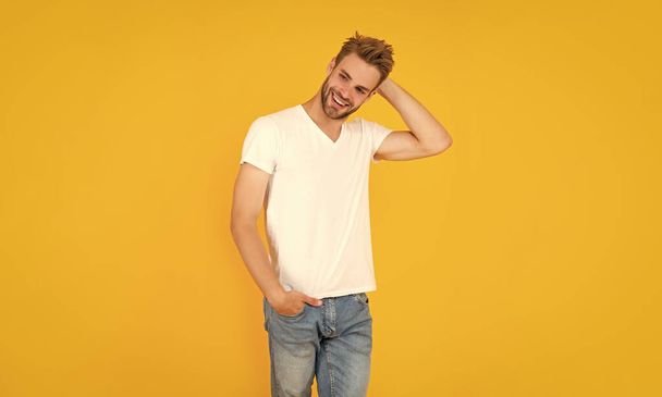 smiling unshaven young man in white shirt on yellow background, mens beauty. - Foto, Imagen