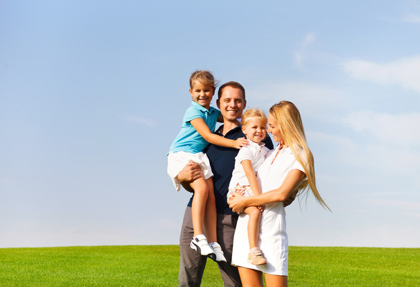 Щаслива молода сім'я з двома дітьми на відкритому повітрі
 - Фото, зображення