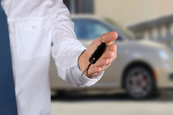 Young successful businessman offering a car key. Close-up of dri - Photo, Image