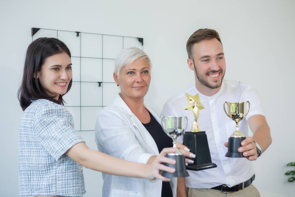 Happy business teamwork success cheerful holding trophy. Group businessperson successful from brainstorming work. partnership diverse company. winner, accept, agreement. - Photo, Image