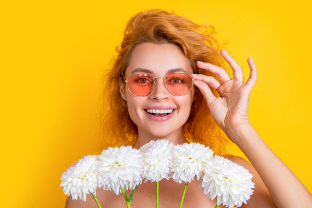 photo of positive girl with womens day chrysanthemum flowers. girl with womens day flowers isolated on yellow. girl with womens day flowers in studio. girl with womens day flowers on background. - Fotografie, Obrázek