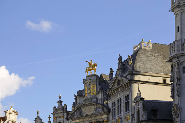 Brussels, Belgium - September 19, 2022: Golden equestrian statue of Charles-Alexandre de Lorraine on the top of the Maison des Brasseurs is visible against the blue sky  - Фото, изображение
