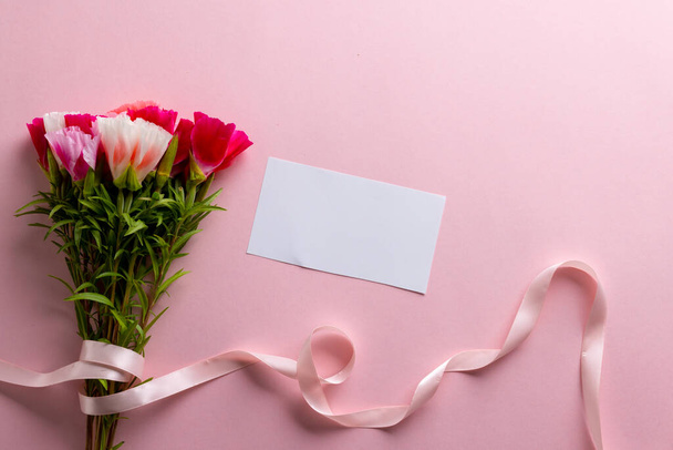 Image of pink and white flowers with ribbon and card with copy space on pink background. Mothers day, nature and spring concept. - Foto, immagini