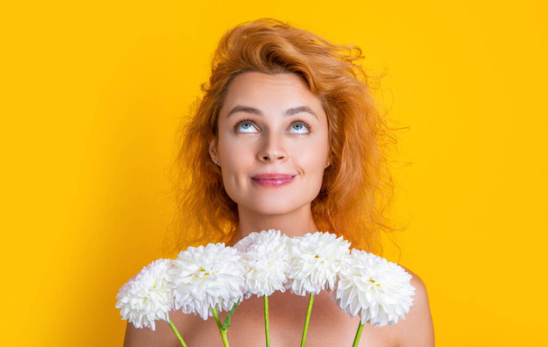 dreamy woman beauty with flowers in studio. woman beauty with flowers on background. photo of woman beauty with chrysanthemum flowers. woman beauty with flowers isolated on yellow. - Valokuva, kuva