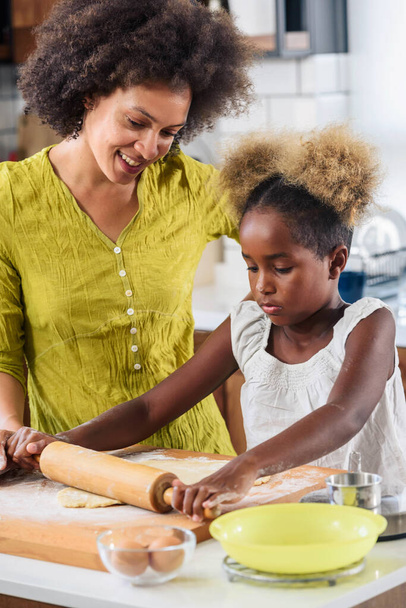 söpö afrikkalainen amerikkalainen äiti ja tytär leivontaan evästeet kotona  - Valokuva, kuva