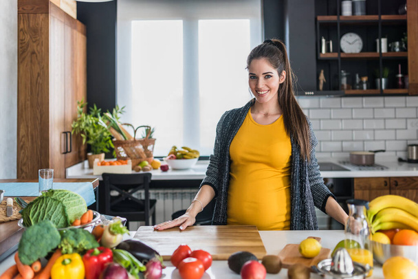 těhotná žena řezání zeleniny  - Fotografie, Obrázek