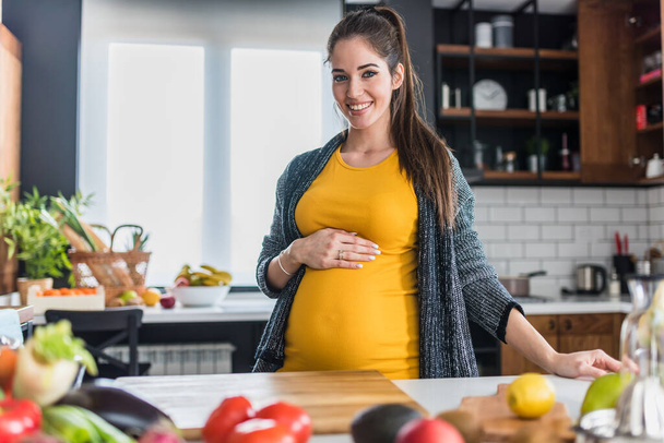 pregnant woman cutting vegetables  - Foto, imagen