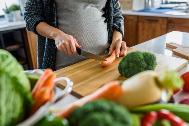 Mujer embarazada cortando verduras
  - Foto, imagen