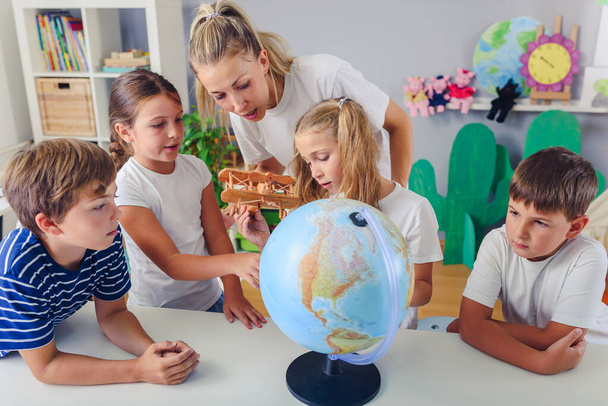 ryhmä lapsia ja opettaja luokkahuoneessa oppiminen maantiede - Valokuva, kuva