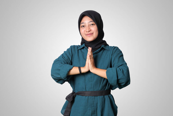 Retrato de mujer asiática alegre hijab en camisa casual, mostrando disculpas y gesto de bienvenida de la mano. Concepto publicitario. Imagen aislada sobre fondo blanco - Foto, imagen